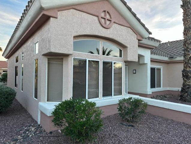 Arched window sun screens cleaned on a tile-roof Phoenix home